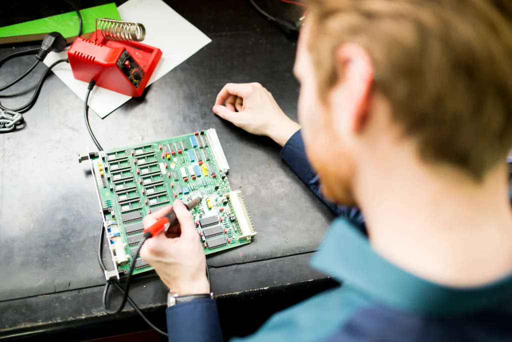 Electrician testing circuit board — electrician website Perth