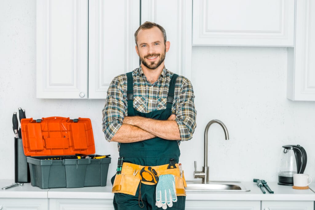 Plumber working under a sink — web design for plumbers